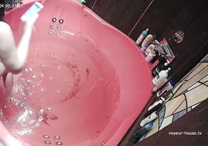 Lovely girl peacefully relaxes naked in red jacuzzi