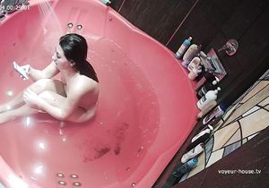 Lovely girl peacefully relaxes naked in red jacuzzi